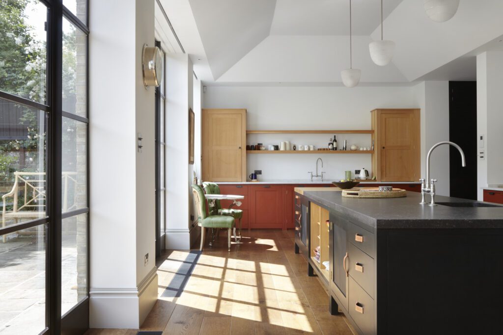 Bespoke kitchen with floor cupboards painted in rusty nail red, Osea island, and pine counter-standing cupboards