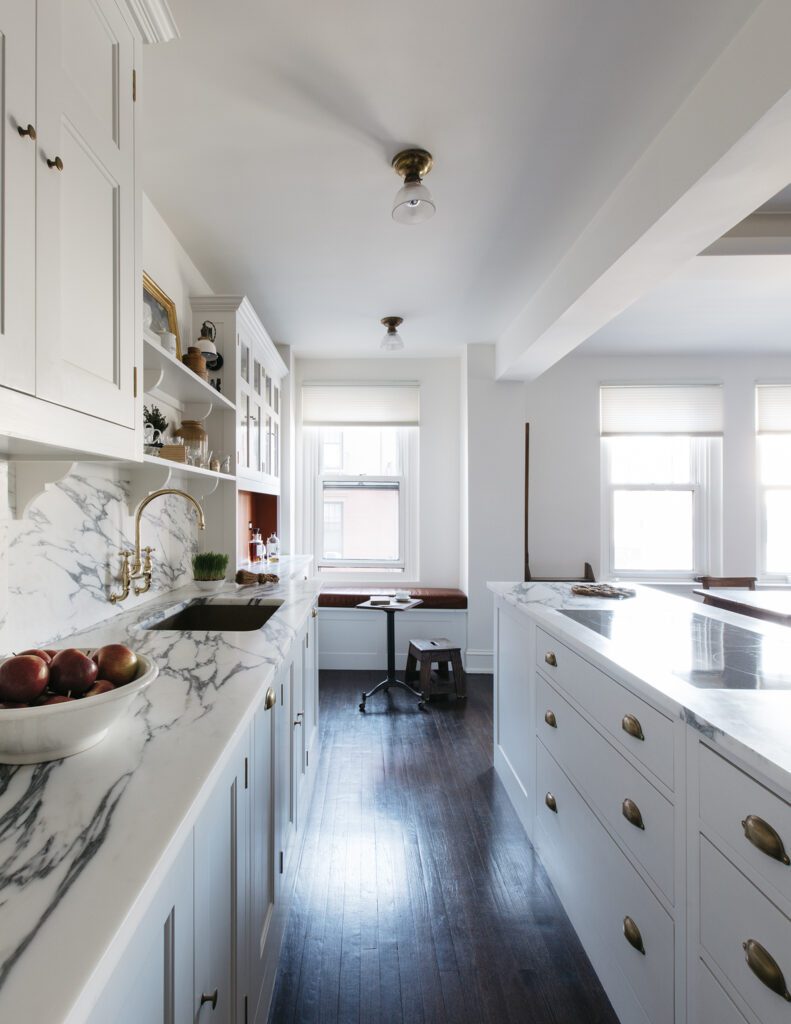 Bespoke white kitchen design with brass hardware and marble countertops
