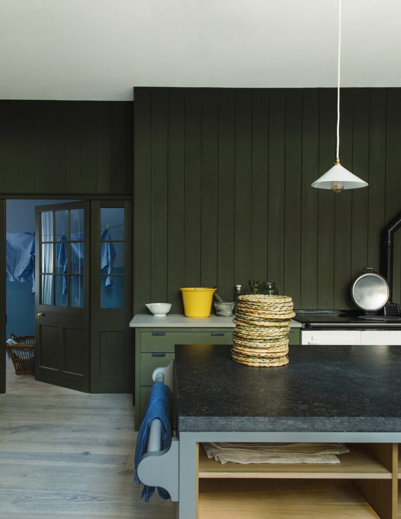 Army green painted kitchen paneling and floor cupboards, kitchen island painted in Plain English's 'tin chest'