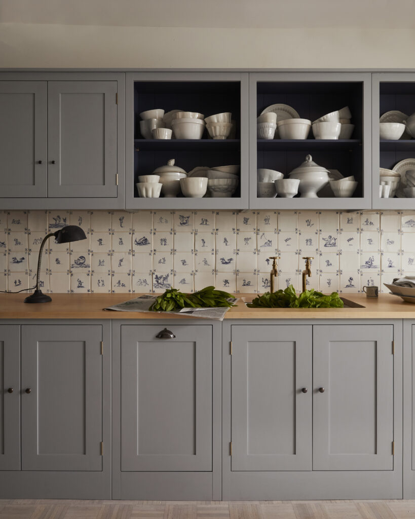 A gray pantry with wood counter and white ceramic bowls