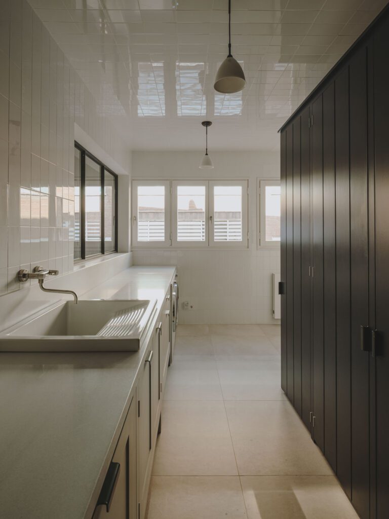 Narrow kitchen with white subway tiles and gray cupboards