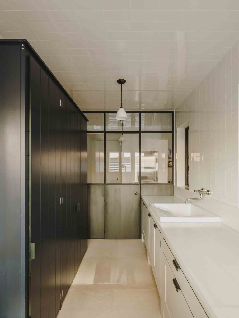 Kitchen with pale green hand-painted cupboards, elegant marble work surfaces, and restored original tiled ceiling