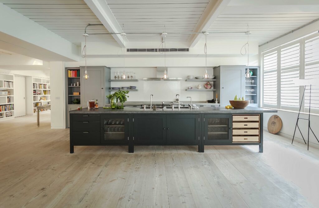 A wide open kitchen space featuring dark cabinets, two gray cupboards, and open shelving