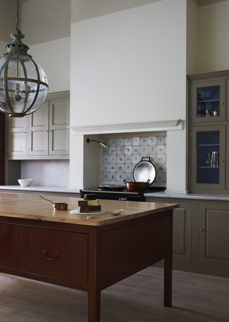 Classic kitchen with Woollen Flump brown cupboards and wooden working table with red and brown paint
