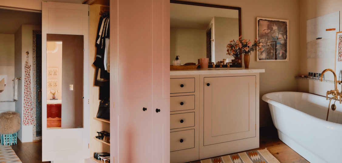  A warm-toned bathroom features a freestanding white bathtub, a cream-colored vanity with a marble countertop, a large mirror, and a partially open wardrobe with a pink door, all accented by soft lighting and floral decor.